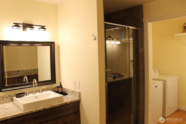 full bathroom with a shower stall, washer and clothes dryer, and vanity