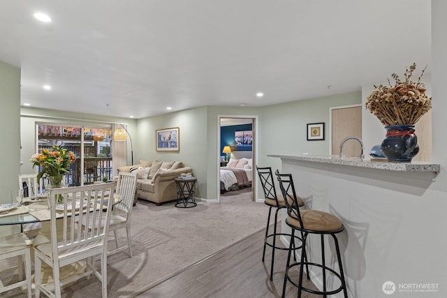 interior space with a sink, recessed lighting, baseboards, and wood finished floors