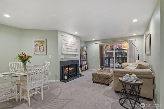 living area featuring carpet flooring, recessed lighting, baseboards, and a fireplace with flush hearth