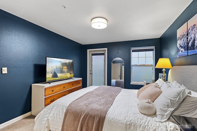 bedroom with baseboards, carpet, and a textured wall