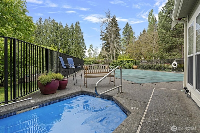 view of swimming pool featuring a patio and fence