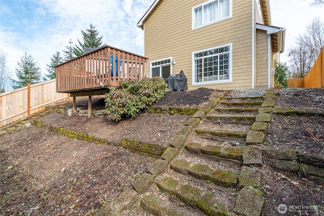 back of house with a deck and fence