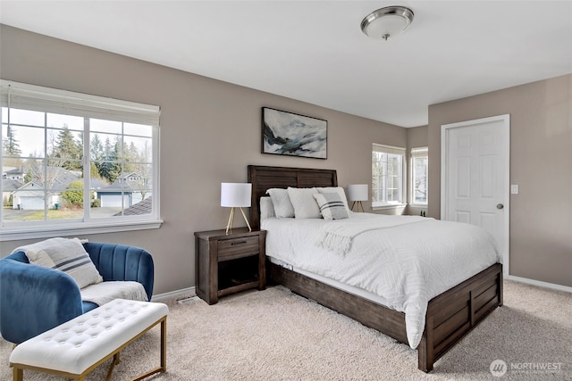 bedroom featuring baseboards and light colored carpet