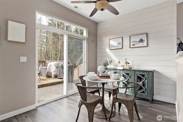 dining space with a ceiling fan, baseboards, visible vents, and wood finished floors