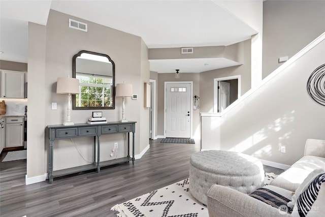 entryway with dark wood-type flooring, visible vents, and baseboards