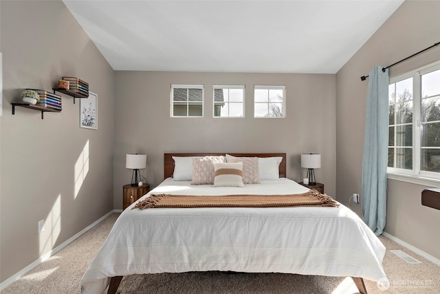 bedroom featuring light carpet, baseboards, and vaulted ceiling