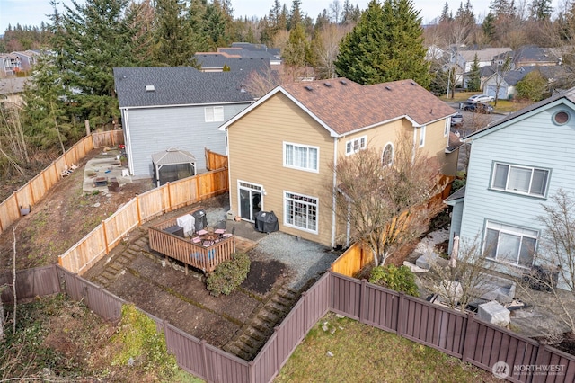 back of house with a fenced backyard and a deck