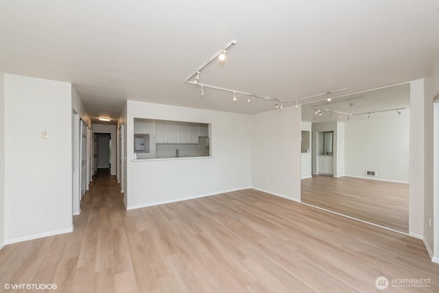 1221 Harbor Ave SW Unit 105, Seattle, WA 98116 - unfurnished living room with light wood-style flooring, baseboards, and track lighting