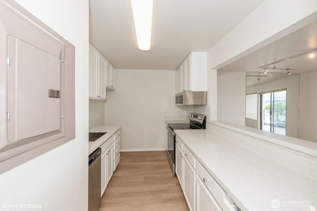 1221 Harbor Ave SW Unit 105, Seattle, WA 98116 - kitchen with stainless steel appliances, white cabinetry, light wood finished floors, and light countertops