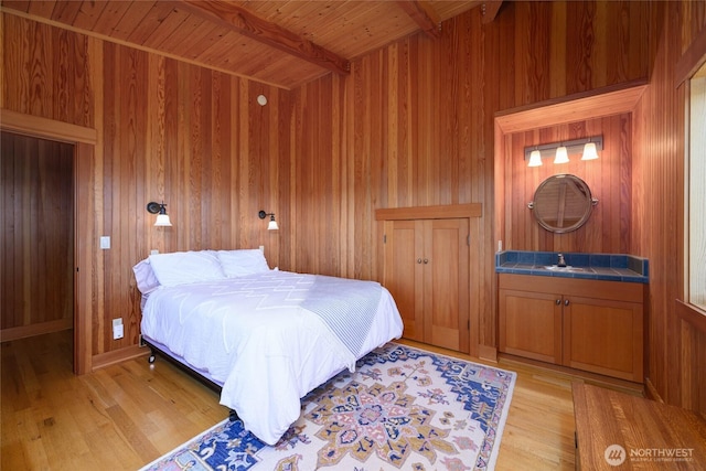 707 NW Thatcher Pass Rd, Decatur Island, WA 98221 - bedroom featuring wood ceiling, wood walls, beamed ceiling, and light wood-type flooring