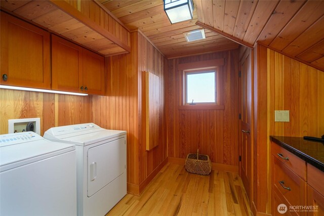 707 NW Thatcher Pass Rd, Decatur Island, WA 98221 - clothes washing area with independent washer and dryer, light wood-style flooring, wooden ceiling, wood walls, and cabinet space