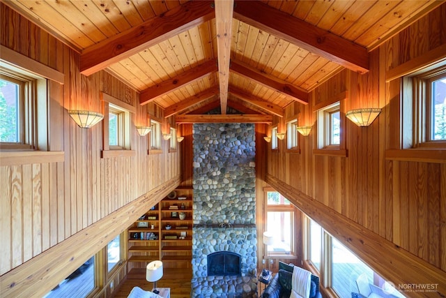 707 NW Thatcher Pass Rd, Decatur Island, WA 98221 - unfurnished living room with wood walls, a stone fireplace, vaulted ceiling with beams, and wooden ceiling