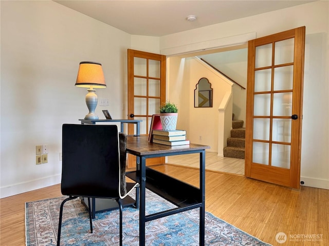 office space with light wood-type flooring and baseboards