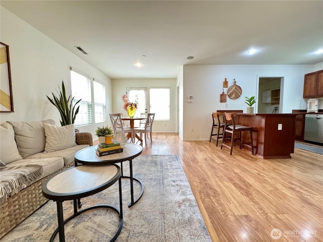 living room with recessed lighting, light wood-type flooring, baseboards, and visible vents