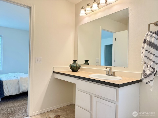 bathroom with vanity, baseboards, and ensuite bathroom