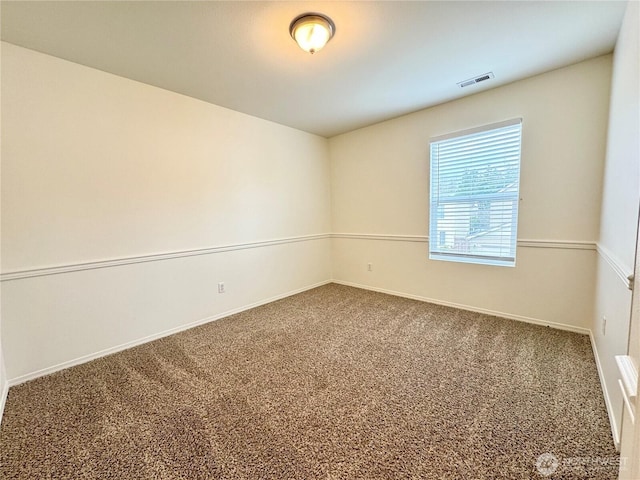 carpeted empty room featuring visible vents and baseboards