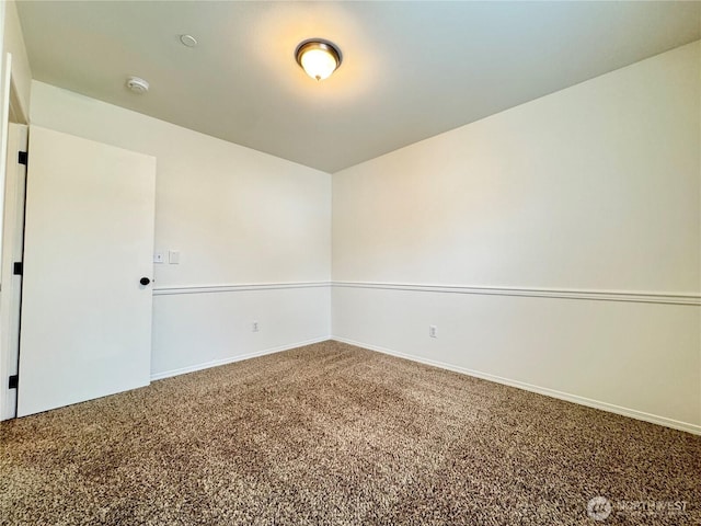 carpeted spare room with baseboards