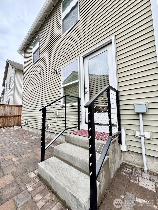 property entrance with a patio and fence