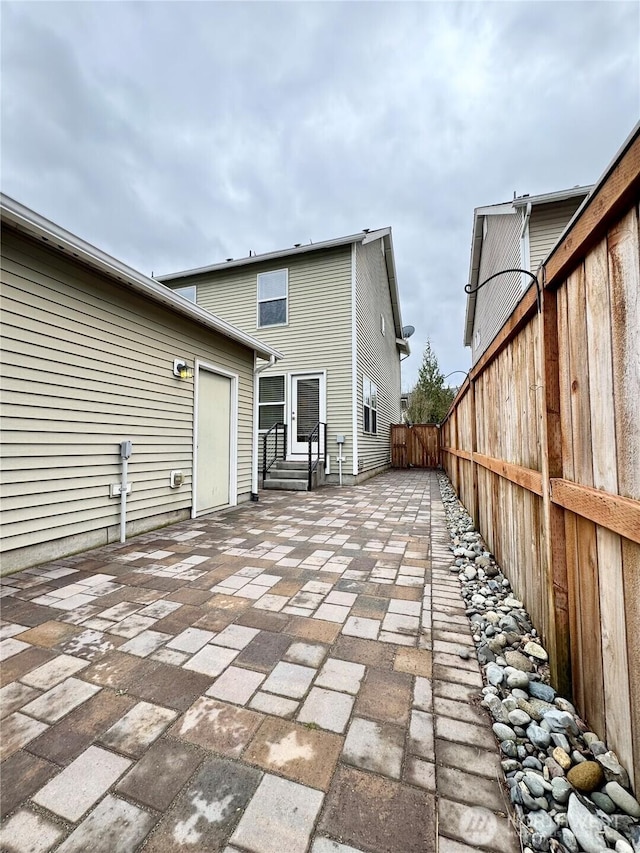 rear view of property featuring a patio, entry steps, and fence