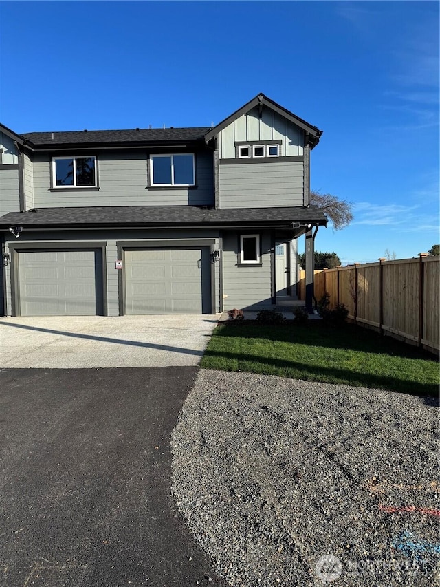 view of front of house featuring driveway, an attached garage, fence, and board and batten siding