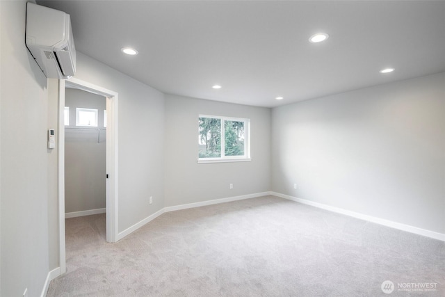 empty room with a wealth of natural light, light carpet, recessed lighting, and a wall mounted AC