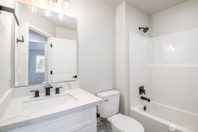 bathroom featuring vanity, shower / tub combination, and toilet