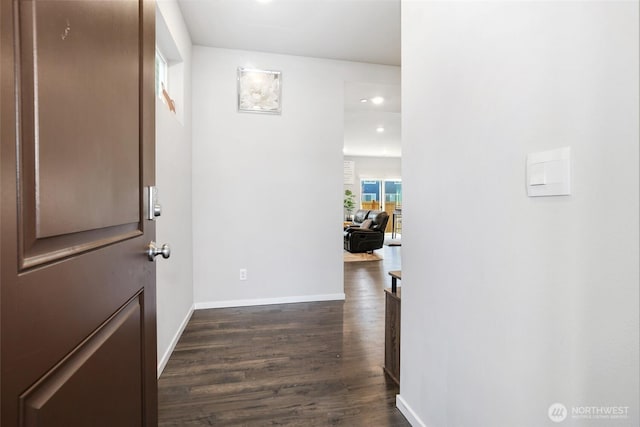 corridor with dark wood-type flooring, recessed lighting, and baseboards