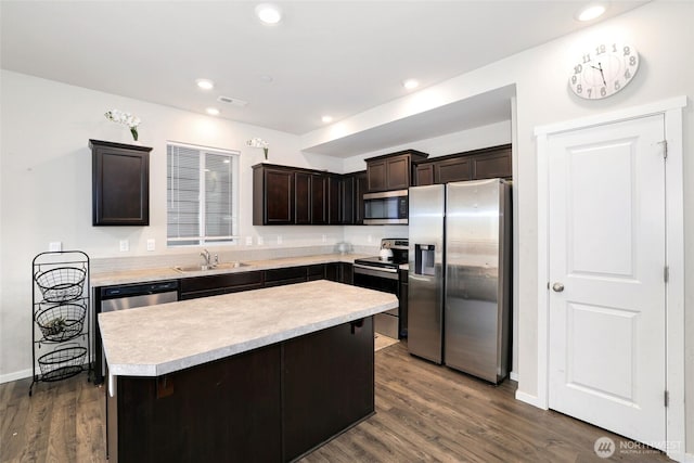 kitchen featuring visible vents, dark brown cabinetry, light countertops, a sink, and stainless steel appliances