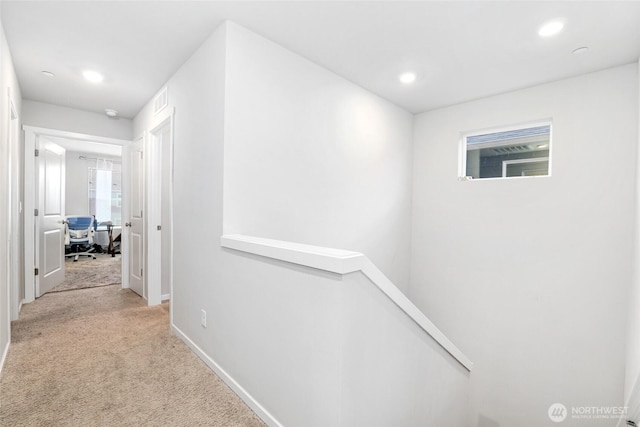 corridor featuring visible vents, baseboards, an upstairs landing, light carpet, and recessed lighting