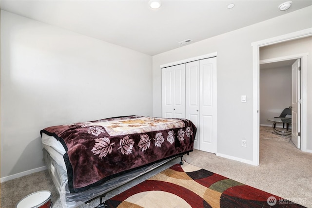 bedroom with baseboards, visible vents, carpet, and a closet