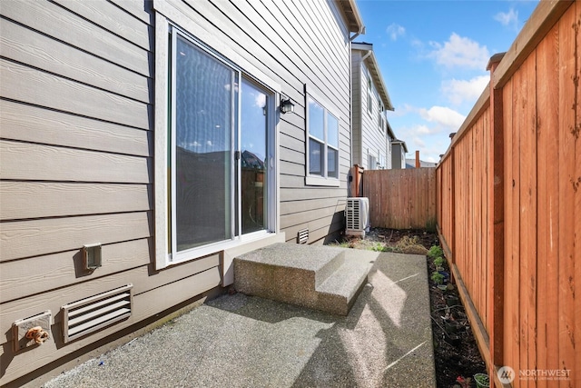 view of side of property with a fenced backyard and cooling unit