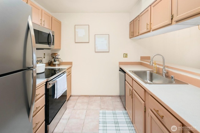 kitchen featuring light brown cabinets, light countertops, appliances with stainless steel finishes, and a sink