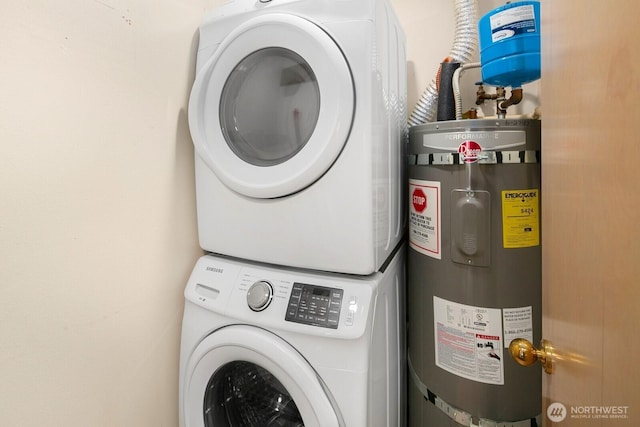 laundry room featuring laundry area, water heater, and stacked washer / drying machine