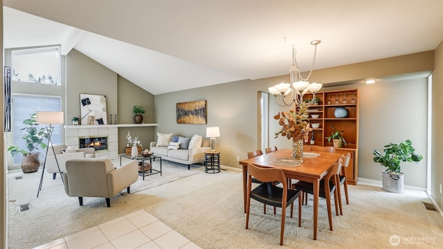 carpeted dining area with baseboards, visible vents, lofted ceiling with beams, a fireplace, and a chandelier