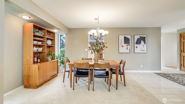 dining space with a notable chandelier, baseboards, and light tile patterned floors