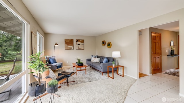 living area with baseboards and tile patterned floors