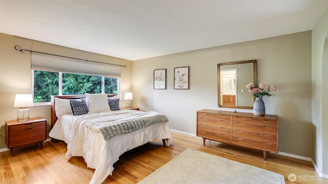 bedroom featuring light wood finished floors and baseboards