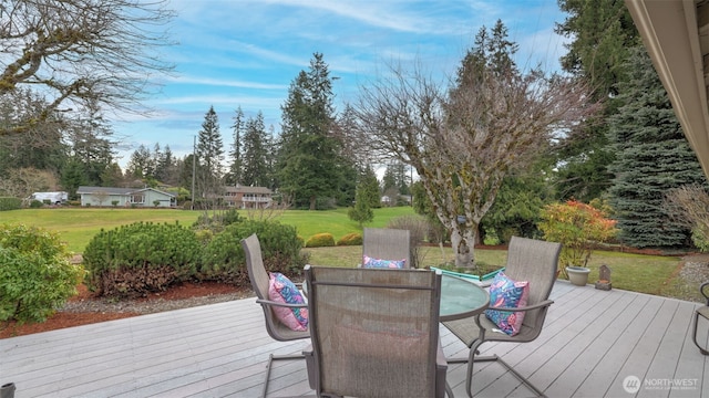 wooden deck with outdoor dining area and a yard