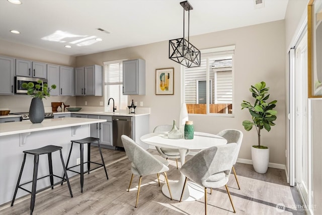 dining area featuring light wood-type flooring, visible vents, baseboards, and recessed lighting