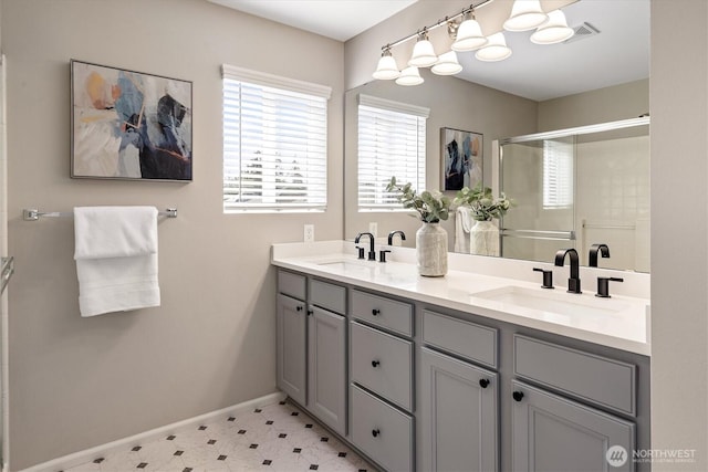 bathroom featuring a shower stall, double vanity, visible vents, and a sink