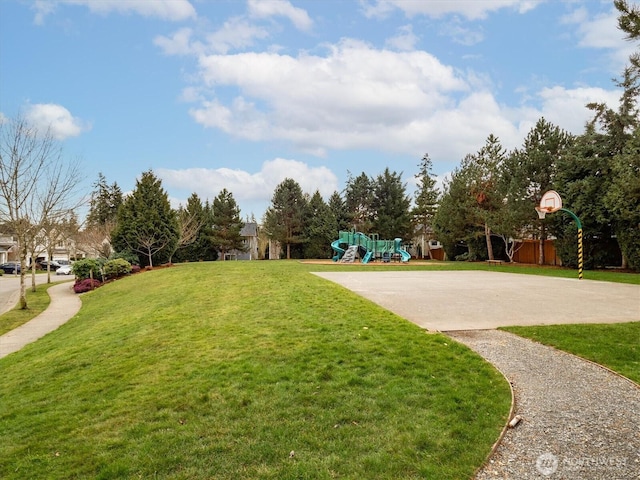 view of home's community featuring concrete driveway, a lawn, and playground community