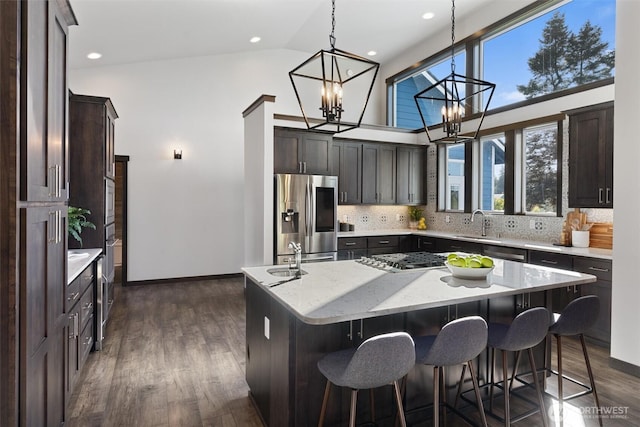 kitchen featuring dark wood-style floors, a kitchen island, appliances with stainless steel finishes, and decorative backsplash