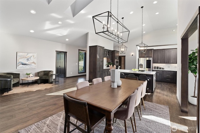 dining area featuring high vaulted ceiling, dark wood finished floors, and recessed lighting