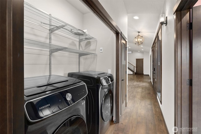 clothes washing area featuring recessed lighting, washing machine and dryer, wood finished floors, a chandelier, and laundry area