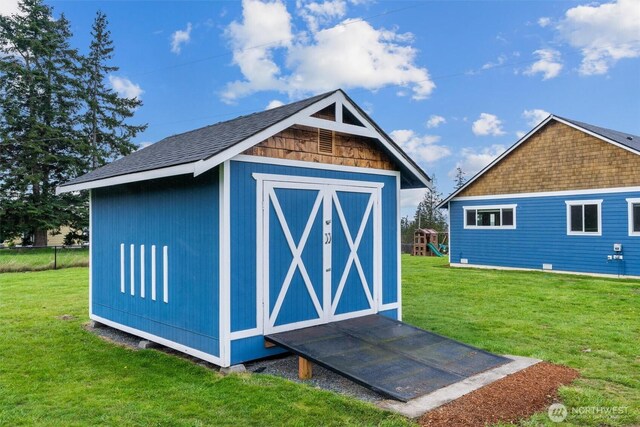 view of shed with a playground and fence