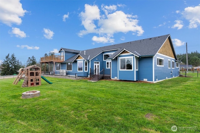 rear view of house featuring central AC unit, a lawn, a playground, and fence