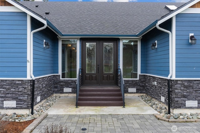 doorway to property with stone siding, crawl space, and roof with shingles