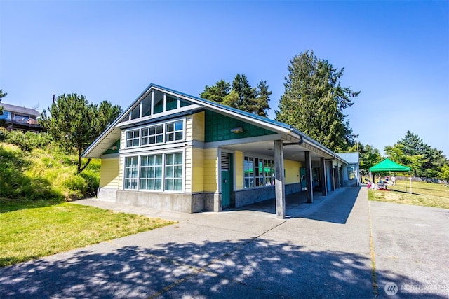 view of front of house featuring driveway, a carport, and a front yard