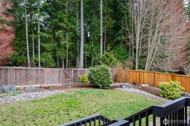 view of yard with a fenced backyard and a gate