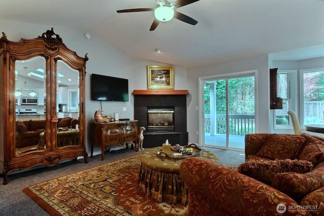 living room featuring carpet floors, a glass covered fireplace, a ceiling fan, and lofted ceiling